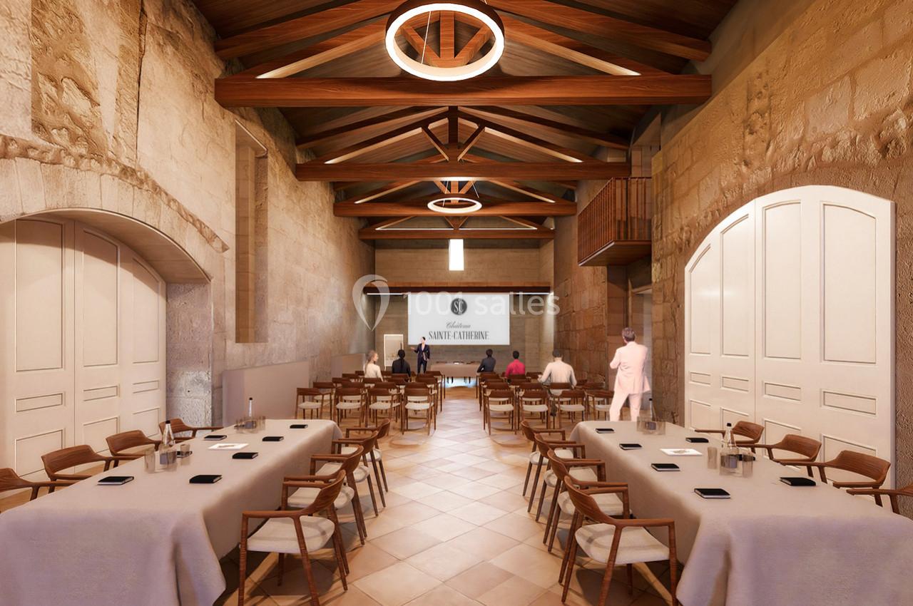 Salle de réunion lumineuse avec murs en pierre, poutres apparentes, tables dressées et écran de projection au fond.