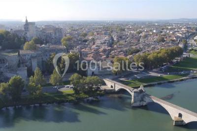 Pont en pierre à arches traversant une rivière, avec des visiteurs et un ciel dégagé en arrière-plan.