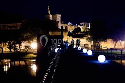 Pont en pierre à arches traversant une rivière, avec des visiteurs et un ciel dégagé en arrière-plan.