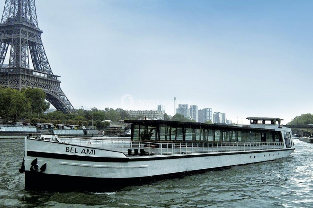 Bateau de croisière naviguant sur la Seine près de la tour Eiffel par temps clair.