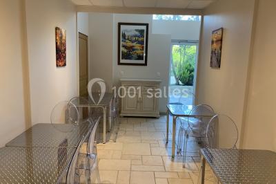 Lit double avec draps blancs dans une chambre mansardée, parquet au sol et poutres apparentes.