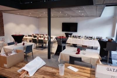 Structure gonflable colorée en forme d'arche, installée sur une cour pavée devant des maisons en briques.