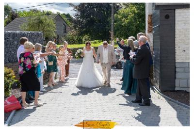 Structure gonflable colorée en forme d'arche, installée sur une cour pavée devant des maisons en briques.