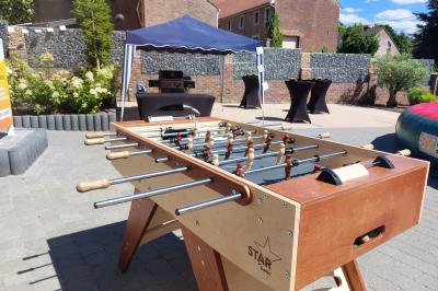 Structure gonflable colorée en forme d'arche, installée sur une cour pavée devant des maisons en briques.