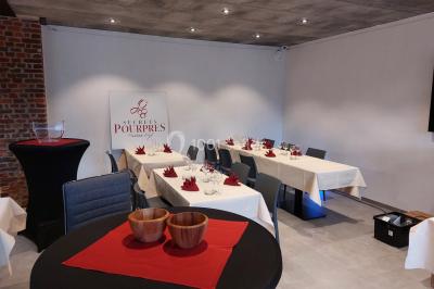 Salle de réunion moderne avec chaises disposées en rangées, tables hautes et grandes baies vitrées laissant entrer la…