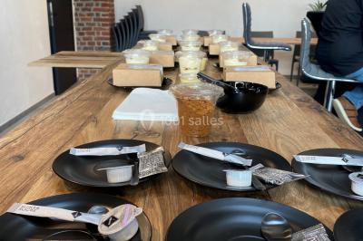 Salle de réunion moderne avec chaises disposées en rangées, tables hautes et grandes baies vitrées laissant entrer la…