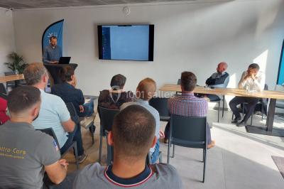 Salle de réunion moderne avec chaises disposées en rangées, tables hautes et grandes baies vitrées laissant entrer la…