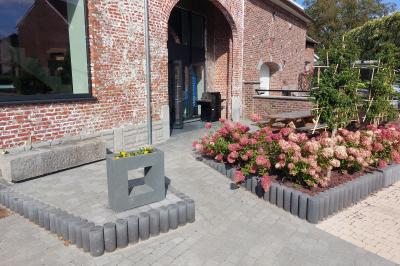Salle de réunion moderne avec chaises disposées en rangées, tables hautes et grandes baies vitrées laissant entrer la…