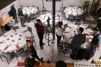 Salle de réunion moderne avec chaises disposées en rangées, tables hautes et grandes baies vitrées laissant entrer la…