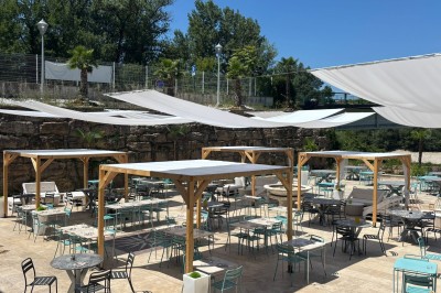 Dessert glacé garni de fraises fraîches, de morceaux de noix et de caramel, présenté sur une assiette blanche.