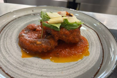 Dessert glacé garni de fraises fraîches, de morceaux de noix et de caramel, présenté sur une assiette blanche.