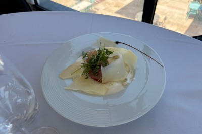 Dessert glacé garni de fraises fraîches, de morceaux de noix et de caramel, présenté sur une assiette blanche.