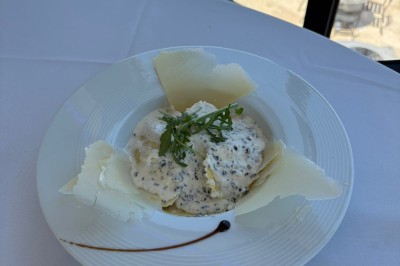 Dessert glacé garni de fraises fraîches, de morceaux de noix et de caramel, présenté sur une assiette blanche.