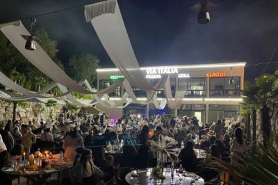 Dessert glacé garni de fraises fraîches, de morceaux de noix et de caramel, présenté sur une assiette blanche.