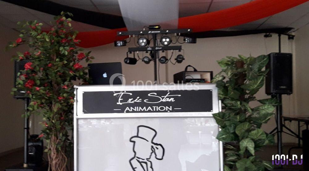 Console de DJ avec éclairages, plantes décoratives et panneau ’Eric Stan Animation’ dans une salle intérieure.