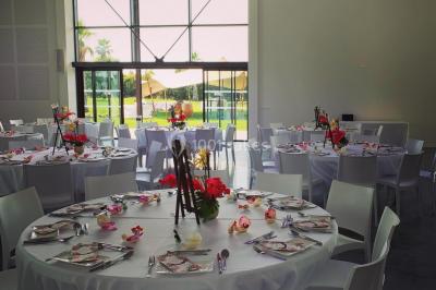 Groupe de personnes rassemblées sur une terrasse et une pelouse, entourées de végétation sous un ciel dégagé.