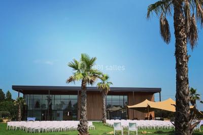 Groupe de personnes rassemblées sur une terrasse et une pelouse, entourées de végétation sous un ciel dégagé.