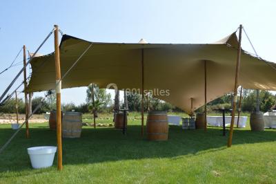 Groupe de personnes rassemblées sur une terrasse et une pelouse, entourées de végétation sous un ciel dégagé.