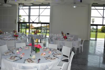 Groupe de personnes rassemblées sur une terrasse et une pelouse, entourées de végétation sous un ciel dégagé.