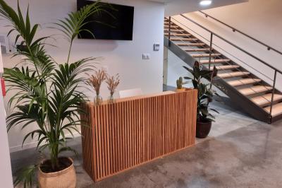Groupe de personnes rassemblées sur une terrasse et une pelouse, entourées de végétation sous un ciel dégagé.