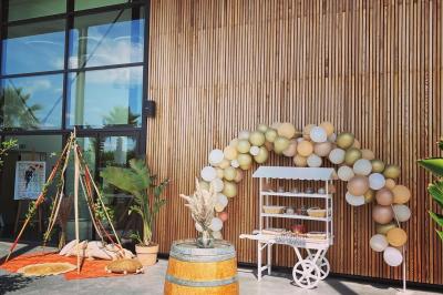 Groupe de personnes rassemblées sur une terrasse et une pelouse, entourées de végétation sous un ciel dégagé.