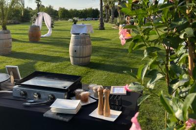Groupe de personnes rassemblées sur une terrasse et une pelouse, entourées de végétation sous un ciel dégagé.