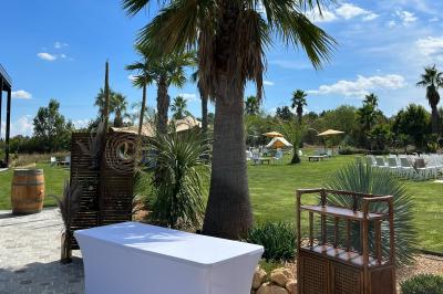 Groupe de personnes rassemblées sur une terrasse et une pelouse, entourées de végétation sous un ciel dégagé.