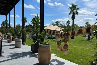 Groupe de personnes rassemblées sur une terrasse et une pelouse, entourées de végétation sous un ciel dégagé.