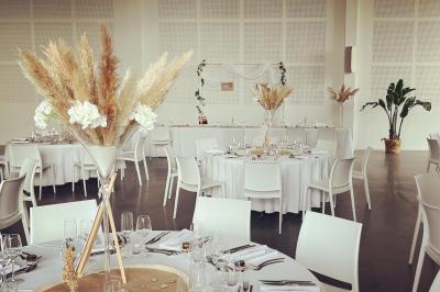 Groupe de personnes rassemblées sur une terrasse et une pelouse, entourées de végétation sous un ciel dégagé.