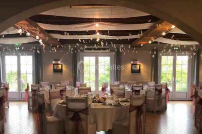 Allée verdoyante ombragée par des arbres, avec une pelouse ensoleillée au centre.