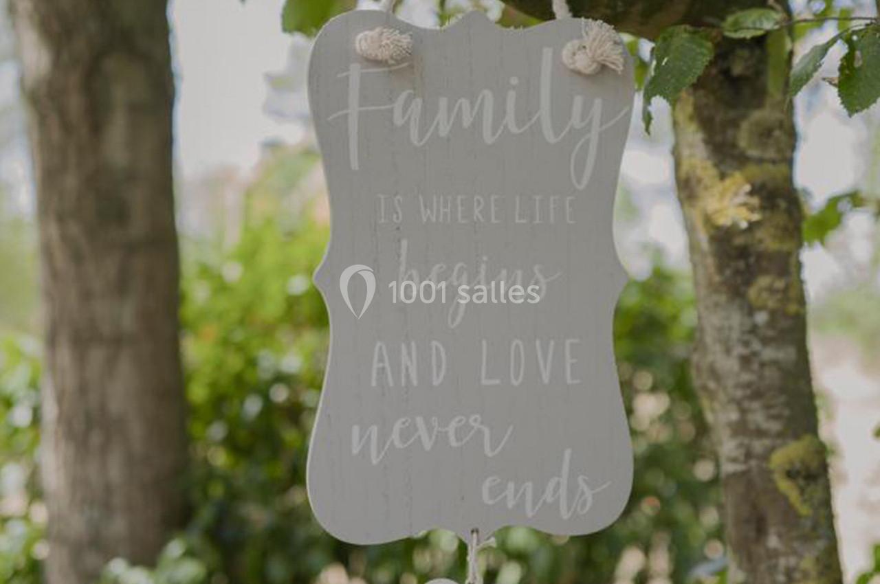 Pancarte suspendue à un arbre, avec l'inscription ’Family is where life begins and love never ends’.
