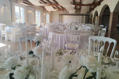 Allée verdoyante ombragée par des arbres, avec une pelouse ensoleillée au centre.