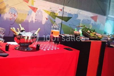 Table élégamment dressée avec nappes blanches, chaises assorties, chandeliers, fleurs roses et couverts dorés.