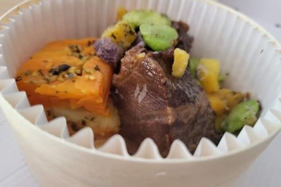 Table élégamment dressée avec nappes blanches, chaises assorties, chandeliers, fleurs roses et couverts dorés.