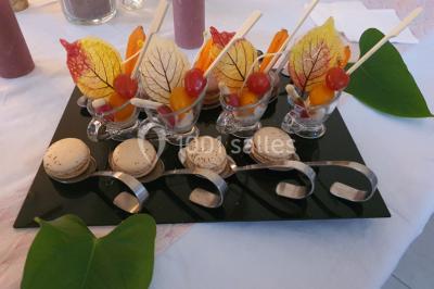 Table élégamment dressée avec nappes blanches, chaises assorties, chandeliers, fleurs roses et couverts dorés.