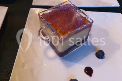 Table élégamment dressée avec nappes blanches, chaises assorties, chandeliers, fleurs roses et couverts dorés.