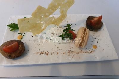 Table élégamment dressée avec nappes blanches, chaises assorties, chandeliers, fleurs roses et couverts dorés.