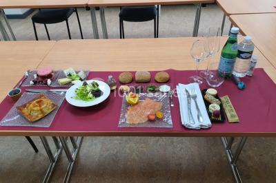 Table élégamment dressée avec nappes blanches, chaises assorties, chandeliers, fleurs roses et couverts dorés.