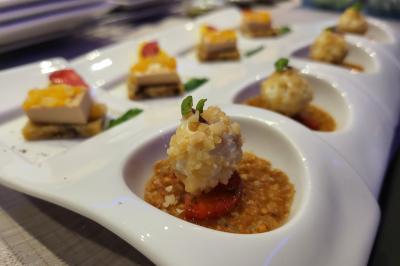 Table élégamment dressée avec nappes blanches, chaises assorties, chandeliers, fleurs roses et couverts dorés.