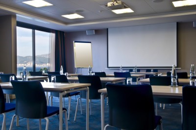 Plateau de fromages variés avec des fruits, dont des raisins, des fraises et un ananas au centre, présenté sur un tonneau.