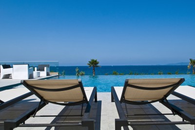 Plateau de fromages variés avec des fruits, dont des raisins, des fraises et un ananas au centre, présenté sur un tonneau.