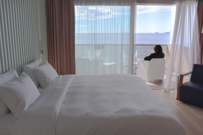 Plateau de fromages variés avec des fruits, dont des raisins, des fraises et un ananas au centre, présenté sur un tonneau.