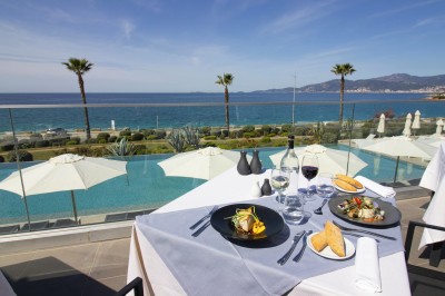 Plateau de fromages variés avec des fruits, dont des raisins, des fraises et un ananas au centre, présenté sur un tonneau.