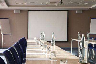 Chambre lumineuse avec lit double, mobilier moderne et vue sur la mer depuis une grande baie vitrée.