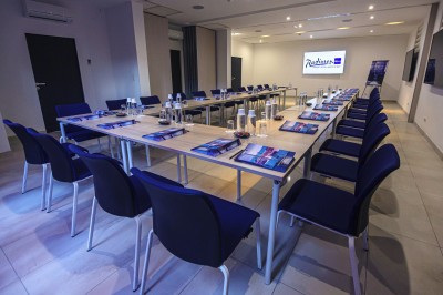 Chambre lumineuse avec lit double, mobilier moderne et vue sur la mer depuis une grande baie vitrée.
