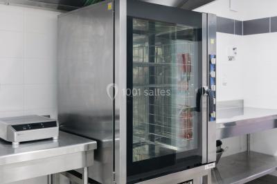 Radiateur sèche-serviettes blanc fixé sur un mur bleu, près d'un lavabo et d'étagères ouvertes.