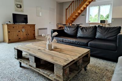 Radiateur sèche-serviettes blanc fixé sur un mur bleu, près d'un lavabo et d'étagères ouvertes.