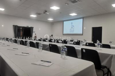 Étang entouré d'arbres illuminés la nuit, avec leurs reflets visibles sur l'eau calme.