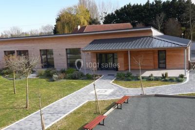 Étang entouré d'arbres illuminés la nuit, avec leurs reflets visibles sur l'eau calme.