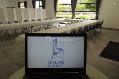 Étang entouré d'arbres illuminés la nuit, avec leurs reflets visibles sur l'eau calme.